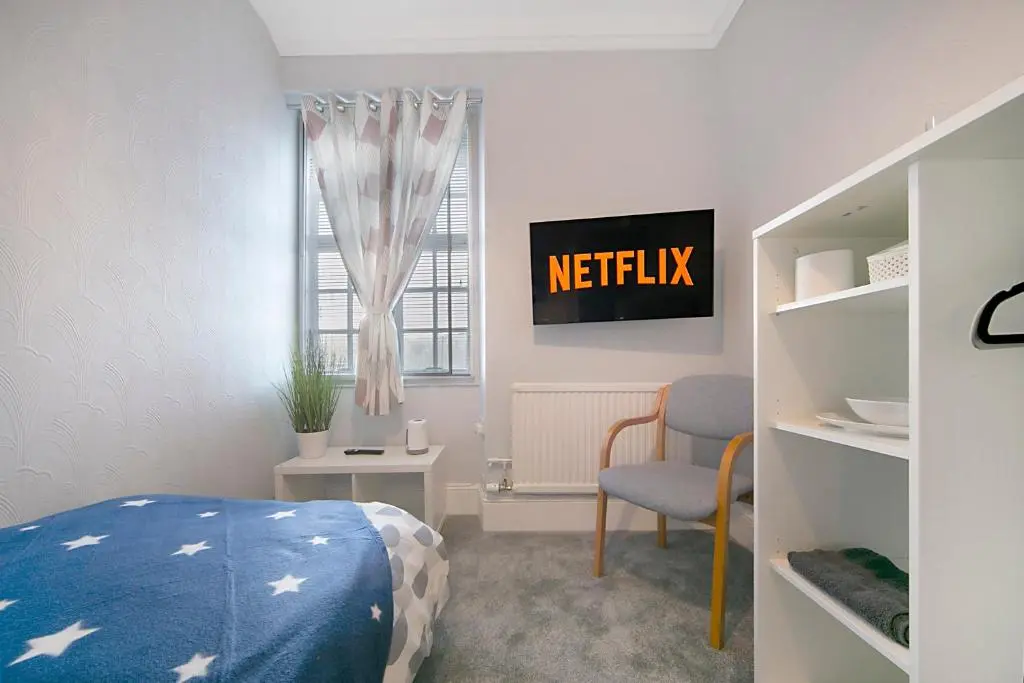 a bedroom with a bed and a chair and a window at Constancevilla B9 - Grampian Lettings Ltd in Aberdeen