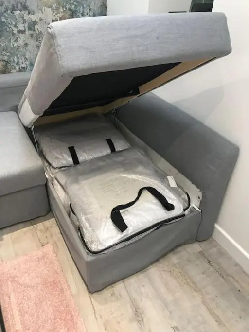 an open box sitting on the floor next to a couch at Riverside Hideaway in Kincraig