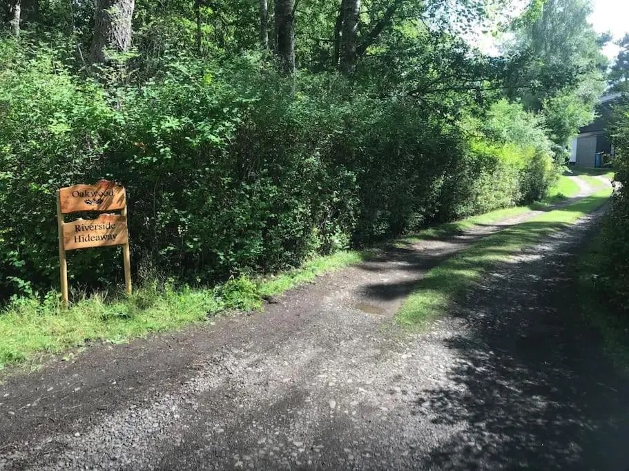 a sign on the side of a dirt road at Riverside Hideaway in Kincraig