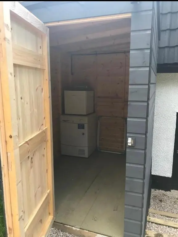 a garage with a door open to a building at Riverside Hideaway in Kincraig