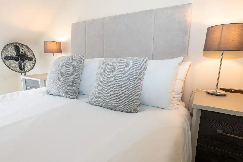 a bedroom with a white bed with two pillows at Loch Ness Gate House in Fort Augustus