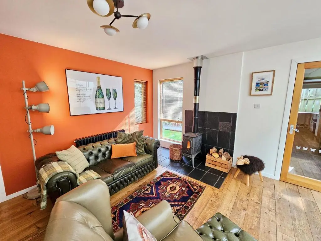 a living room with a couch and a fireplace at Baltinna East - by Where Stags Roar in Newtonmore