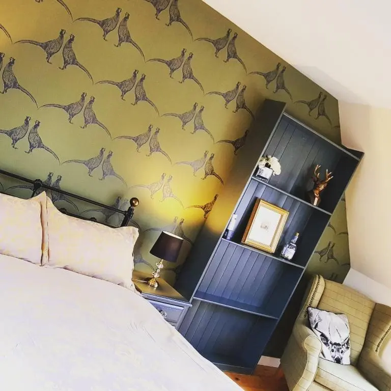 a bedroom with a bed with a dinosaur wallpaper at The Byre - by Where Stags Roar in Newtonmore