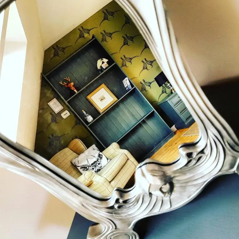 a reflection of a living room in a mirror at The Byre - by Where Stags Roar in Newtonmore