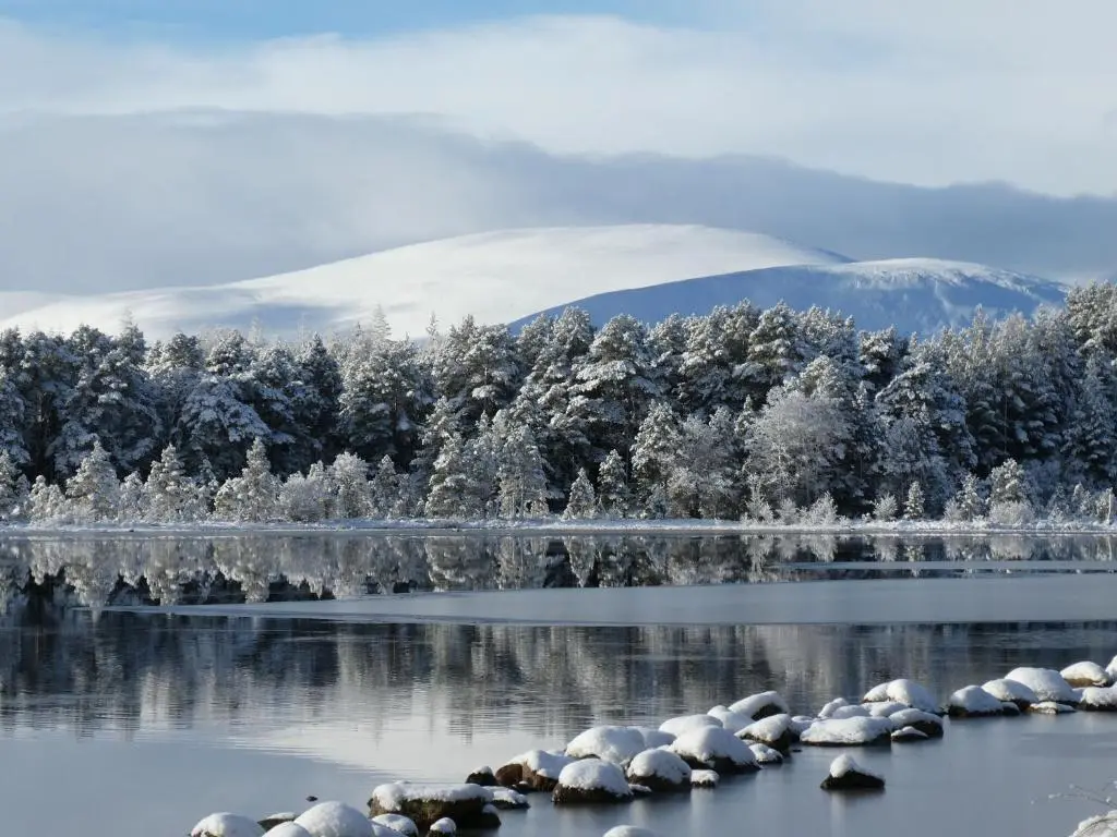 a lake in the snow with a mountain in the background at The Bakehouse - by Where Stags Roar in Newtonmore