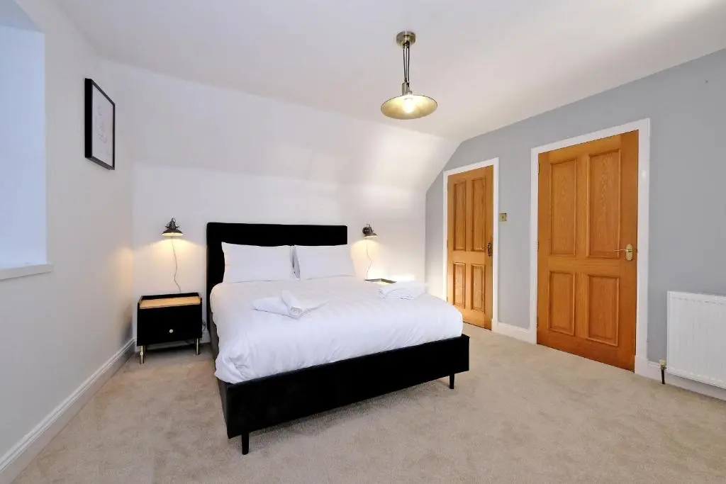 a bedroom with a large bed and a wooden door at Rosebrae in Insch