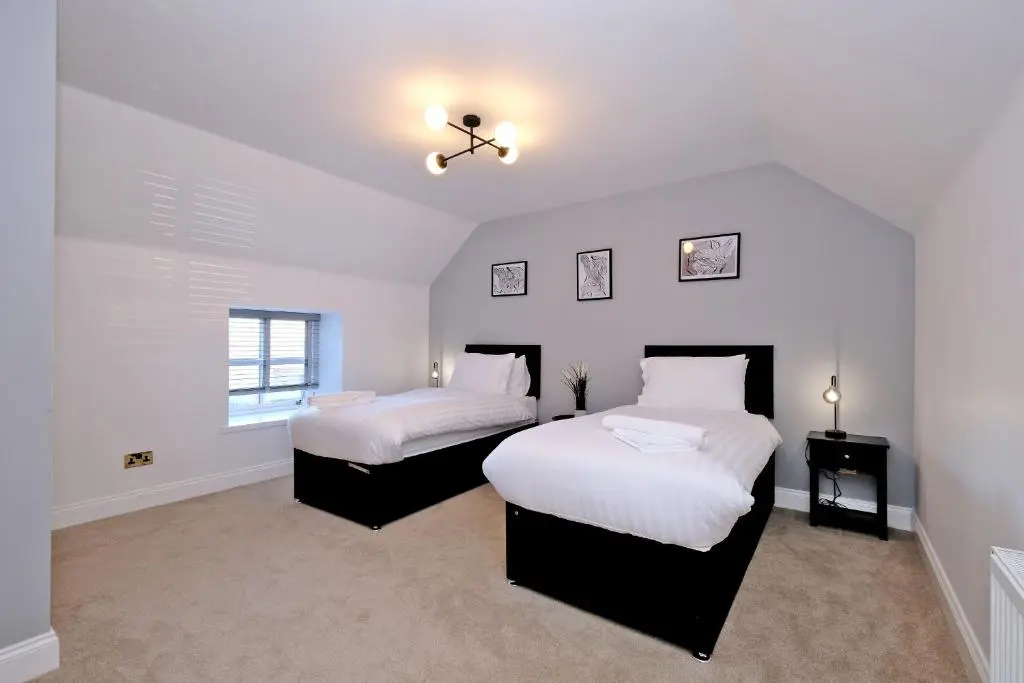 two beds in a room with white walls at Rosebrae in Insch