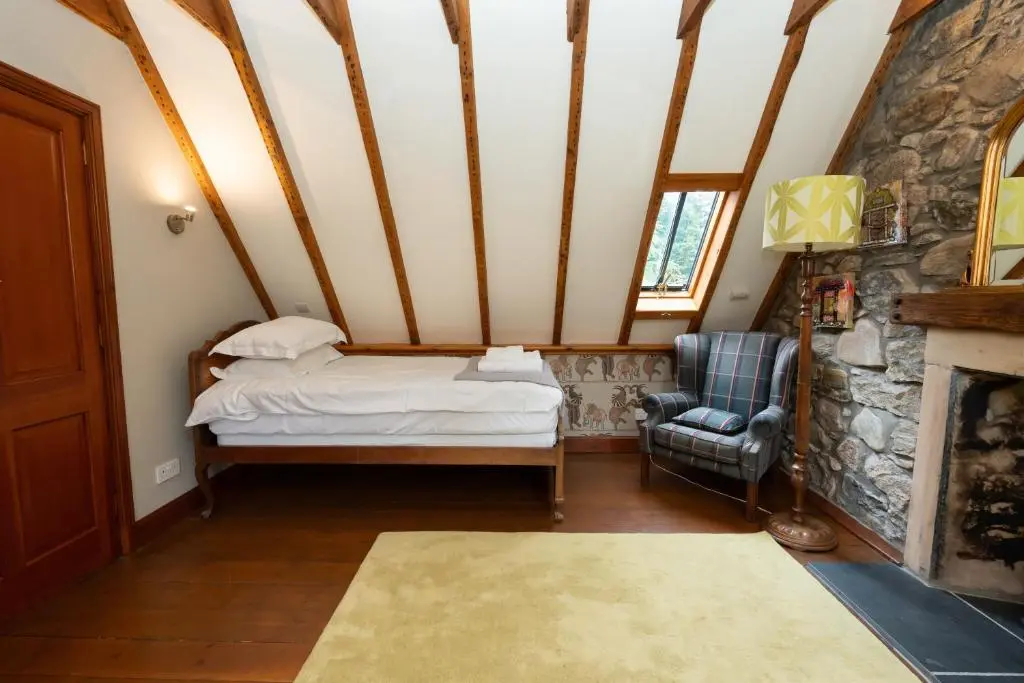 a bedroom with a bed in a room with a fireplace at The Polchar - Aviemore in Aviemore