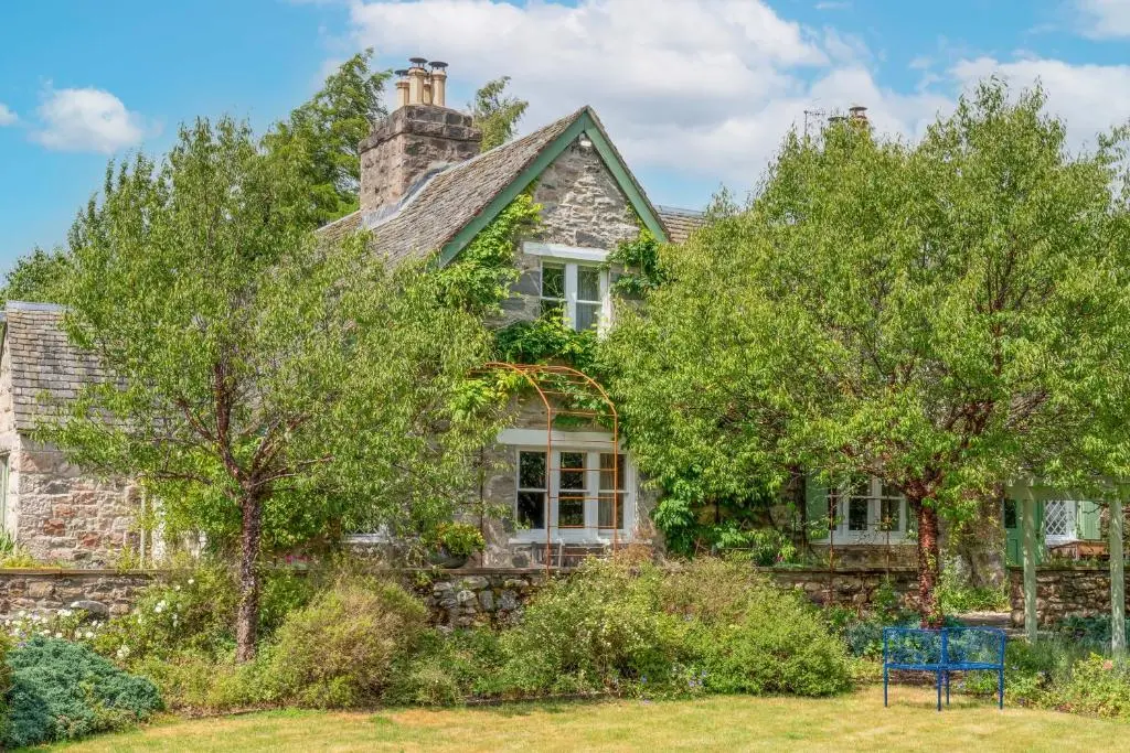 a stone house with trees in front of it at The Polchar - Aviemore in Aviemore