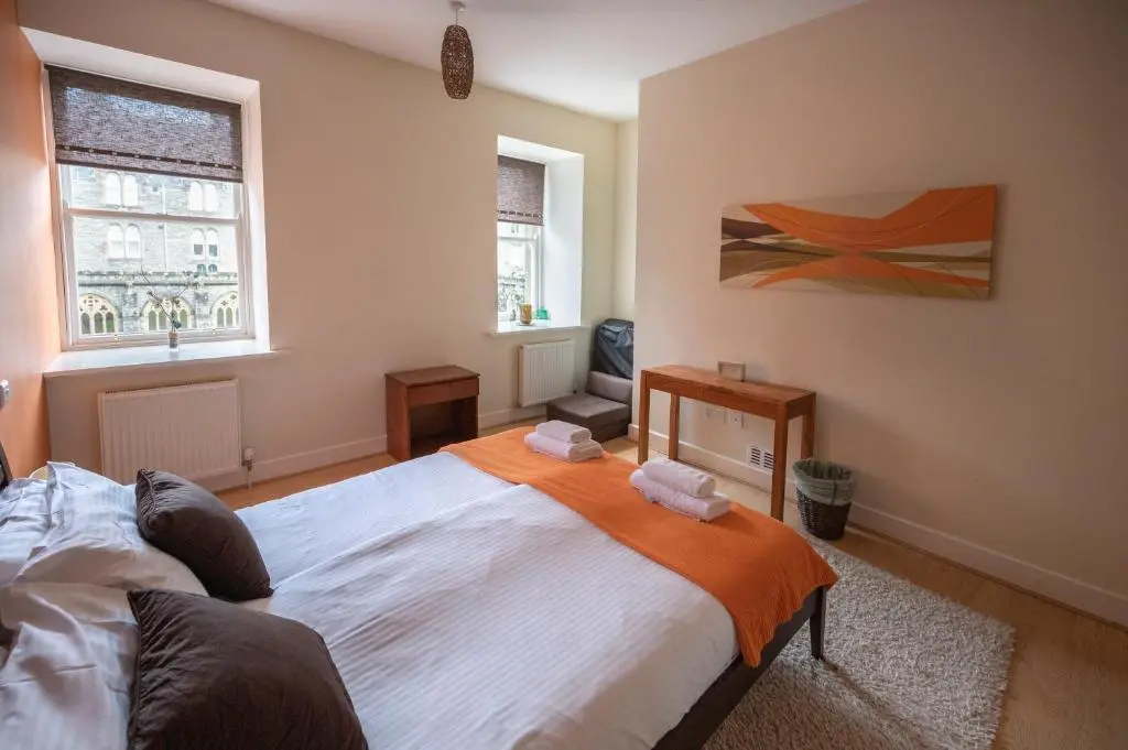a bedroom with a large bed and two windows at Cloister View in Fort Augustus