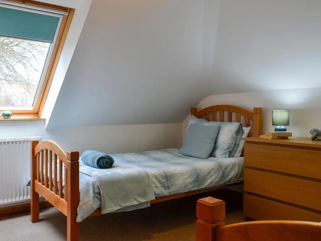 a small bedroom with a bed and a window at Old Mill Cottage in Blair Atholl