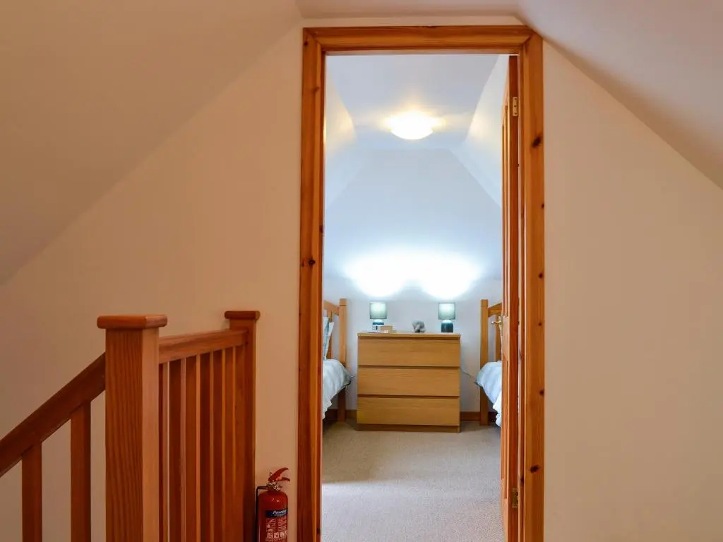 a hallway with a door leading to a bedroom at Old Mill Cottage in Blair Atholl
