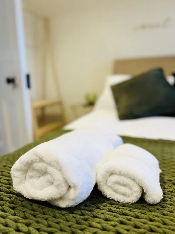 a pair of towels sitting on top of a bed at St Duthus Villa Guesthouse in Tain