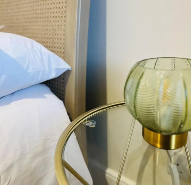 a glass lamp sitting next to a bed at St Duthus Villa Guesthouse in Tain