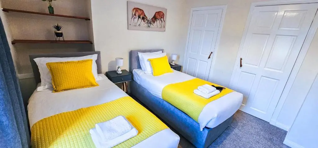 two beds sitting next to each other in a room at mySTAYINN Telford 7 Bedroom House in Inverness