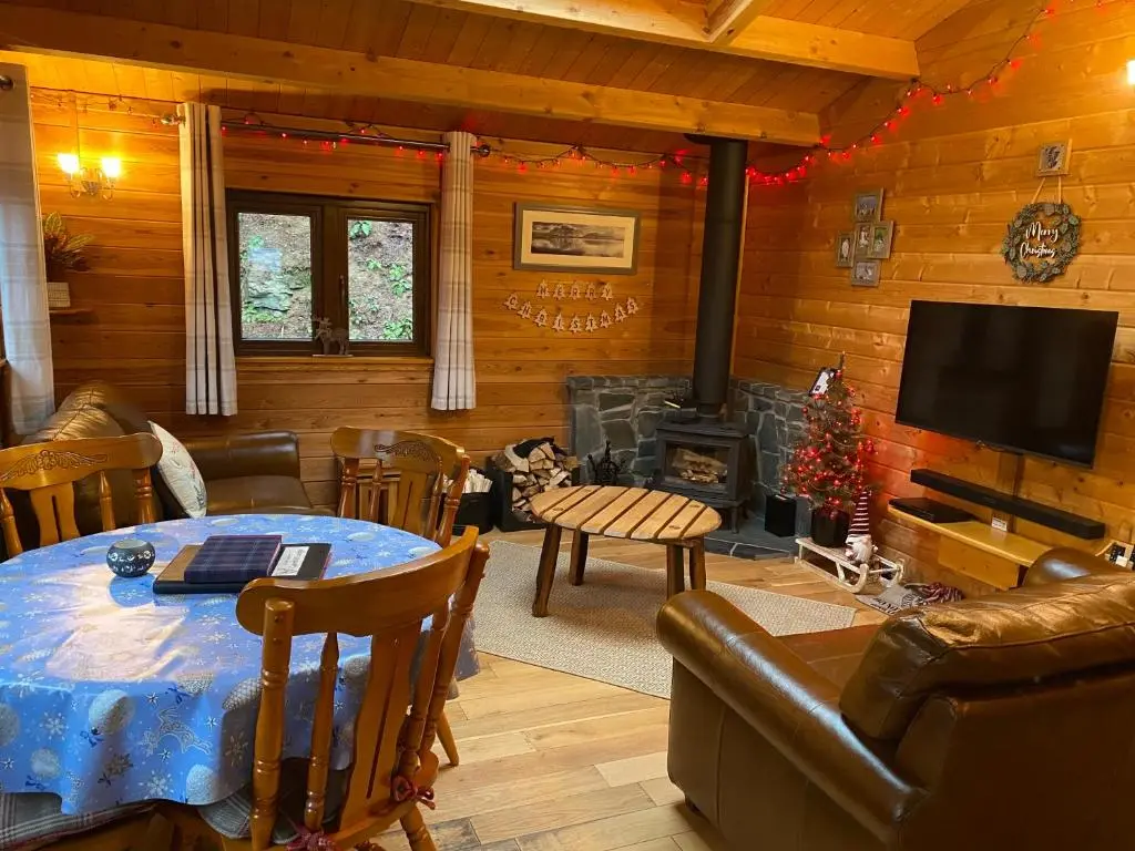 a living room with a table and a fireplace at Cairnhill Lodge - Award-Winning Luxury Highland Retreat in Blairgowrie