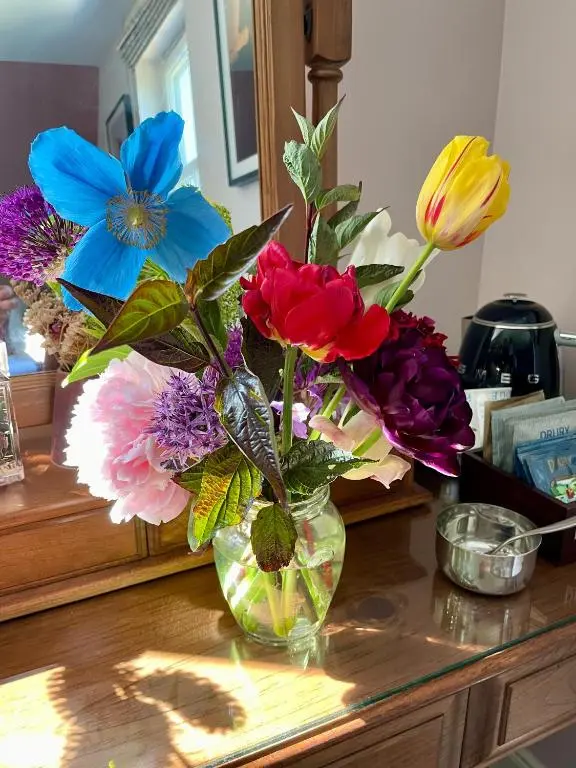 a vase filled with colorful flowers on a counter at Clachan Garden B&B in Garve