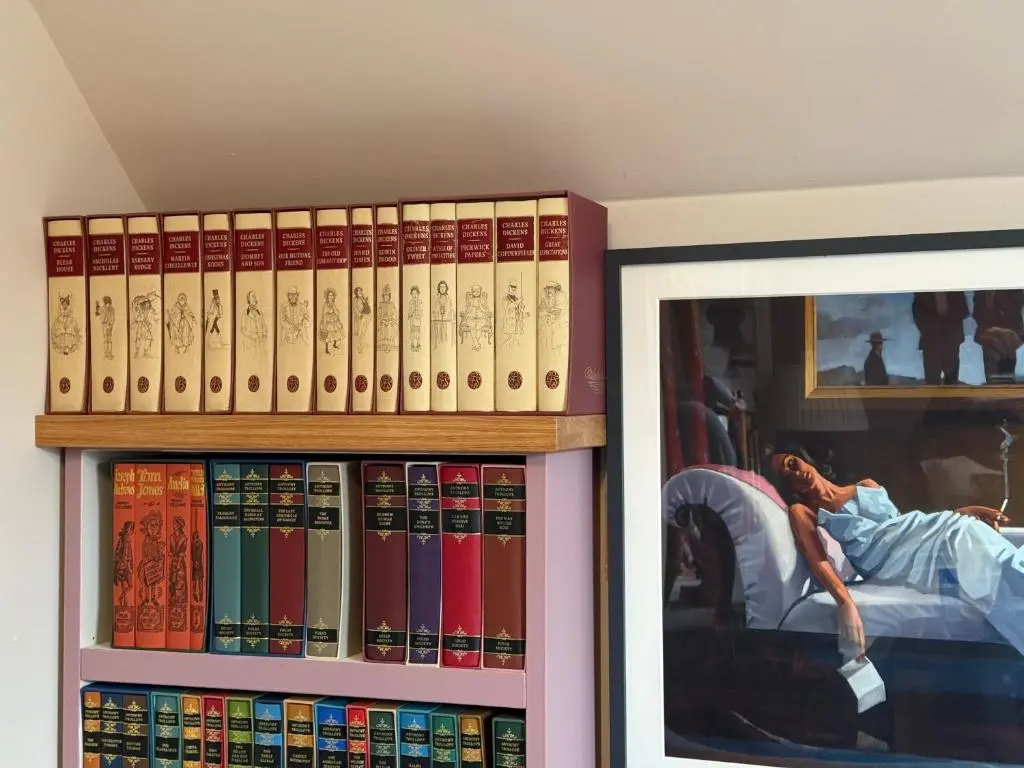 a shelf filled with books next to a doorway at Clachan Garden B&B in Garve