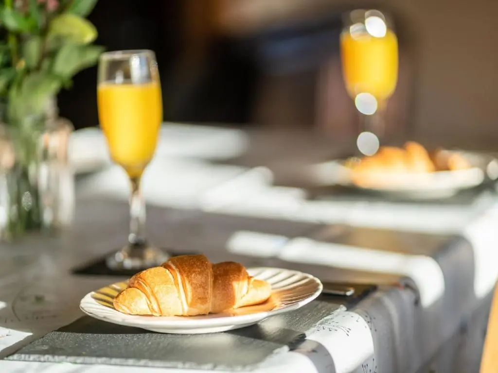 a table with two plates of bread and two glasses of orange juice at Holiday Home Ceilidhtail Cottage by Interhome in Drumnadrochit