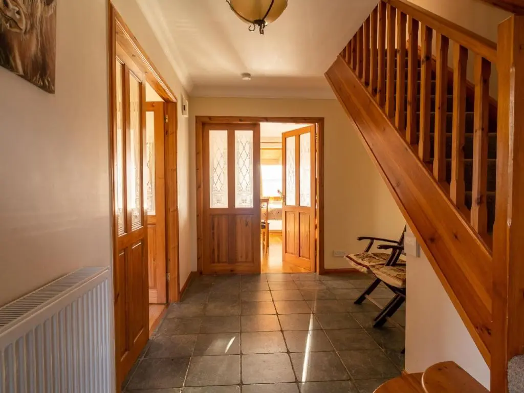 a hallway of a house with a wooden staircase at Holiday Home Ceilidhtail Cottage by Interhome in Drumnadrochit