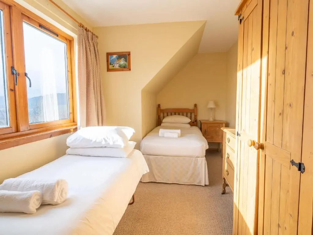 a bedroom with two beds and a window at Holiday Home Ceilidhtail Cottage by Interhome in Drumnadrochit