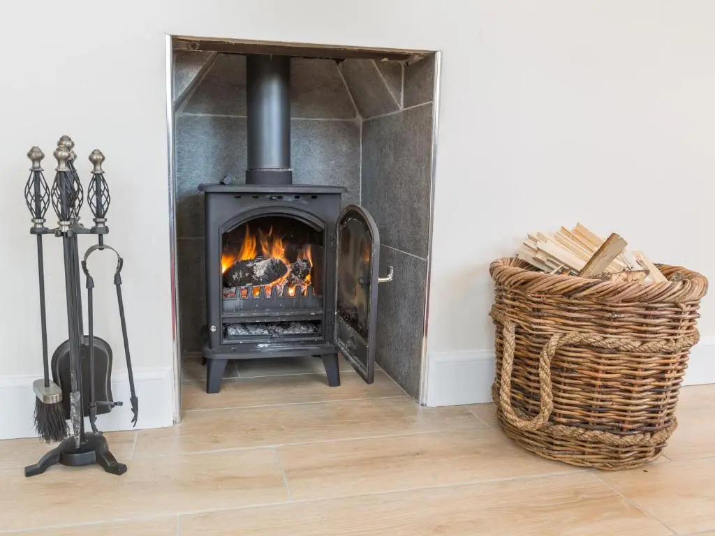 a fireplace in a living room with a stove at Chauffeur's Cottage with Hot Tub in Cray