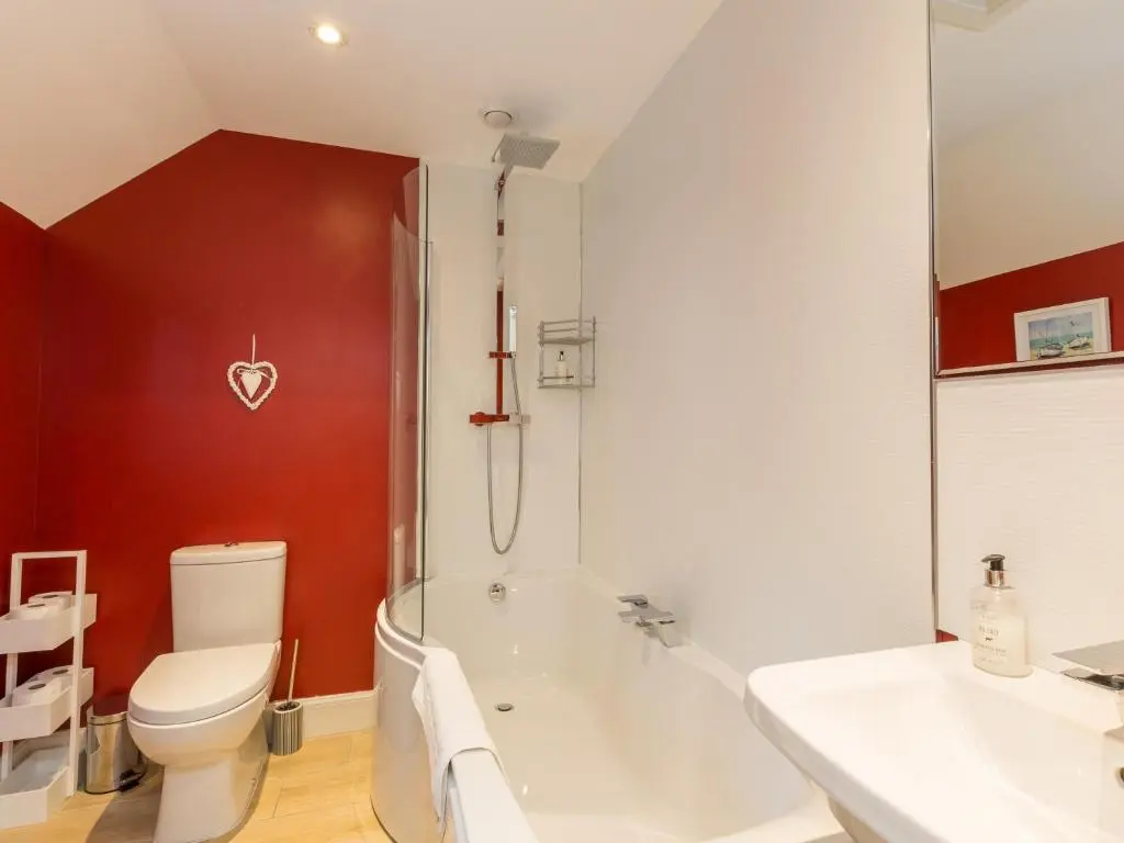 a bathroom with a tub and a toilet and a sink at Chauffeur's Cottage with Hot Tub in Cray