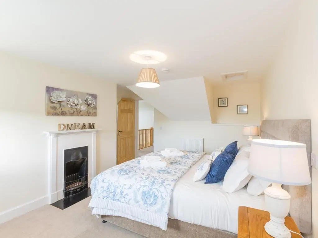 a bedroom with a bed and a fireplace at Chauffeur's Cottage with Hot Tub in Cray