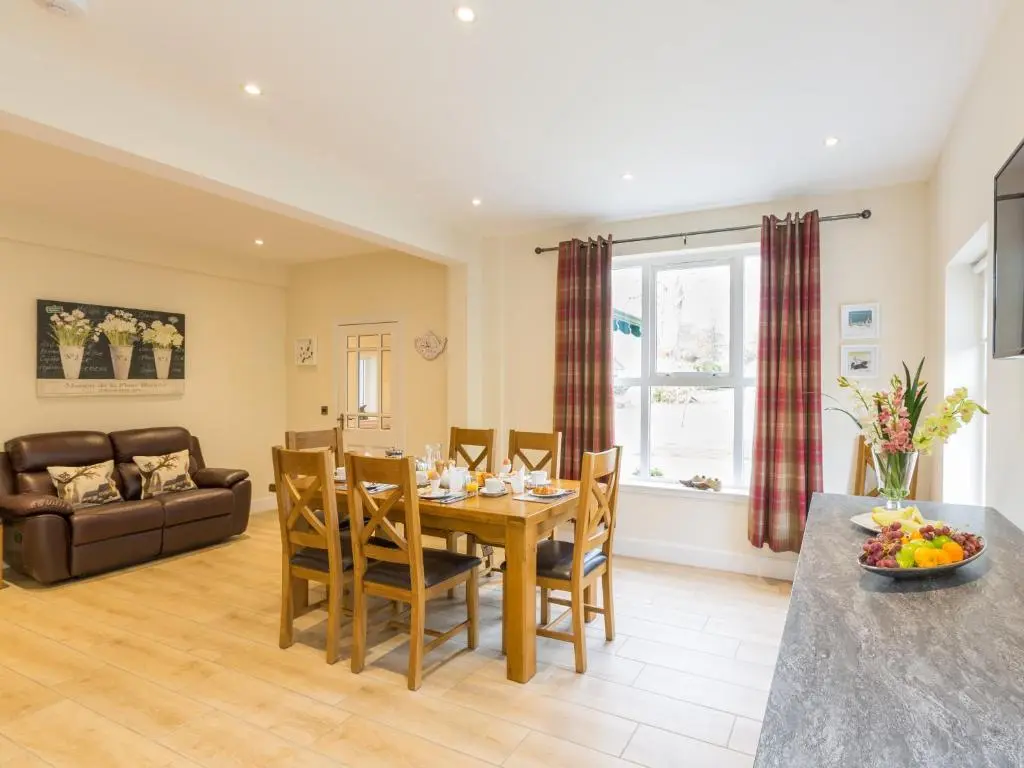 a dining room and living room with a table and chairs at Chauffeur's Cottage with Hot Tub in Cray