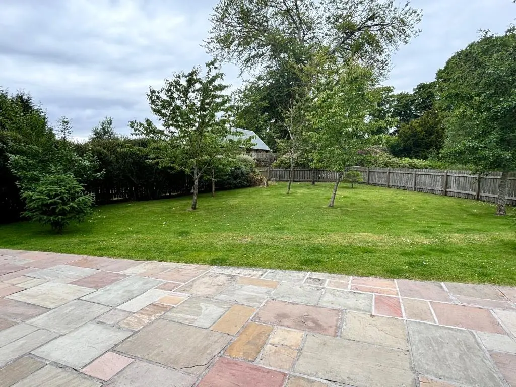 a yard with a lawn with trees and a fence at Chauffeur's Cottage with Hot Tub in Cray
