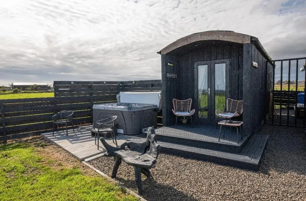 a gazebo with chairs and a bench in a yard at Farr North Lodge 1 By The Sea in Wick