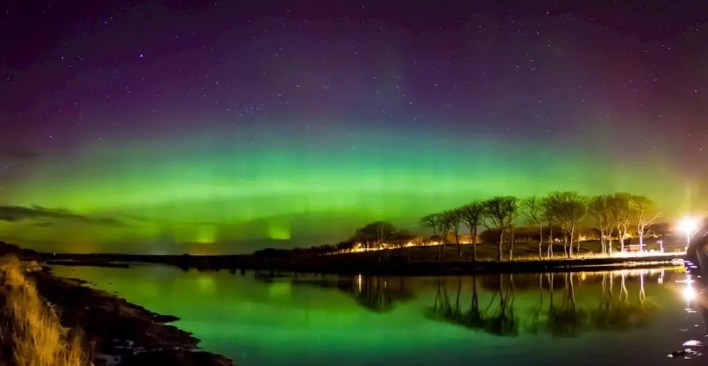 an aurora in the sky over a body of water at Farr North Lodge 1 By The Sea in Wick