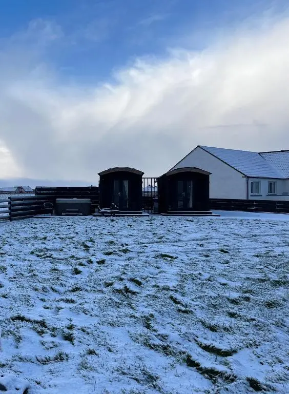 two buildings in a field covered in snow at Farr North Lodge 1 By The Sea in Wick