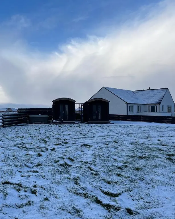 two buildings in a field with snow on the ground at Hot Tub Haven Farr North 2 in Wick