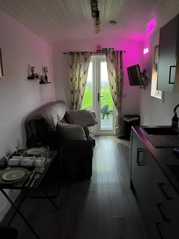 a living room with a couch and a table at Hot Tub Haven Farr North 2 in Wick