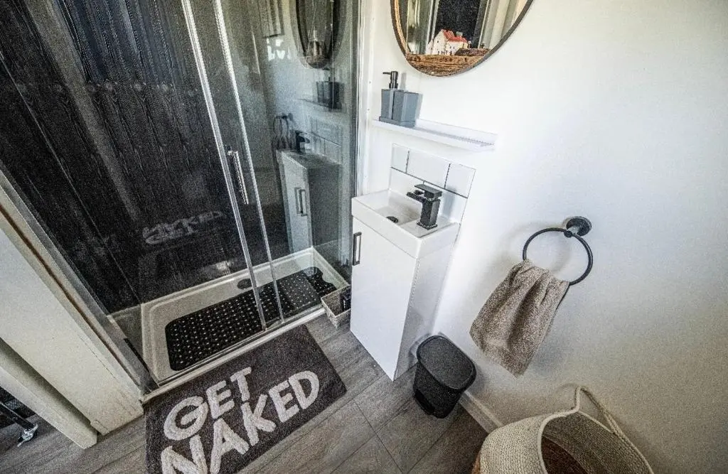 a bathroom with a shower and a toilet and a sink at Hot Tub Haven Farr North 2 in Wick