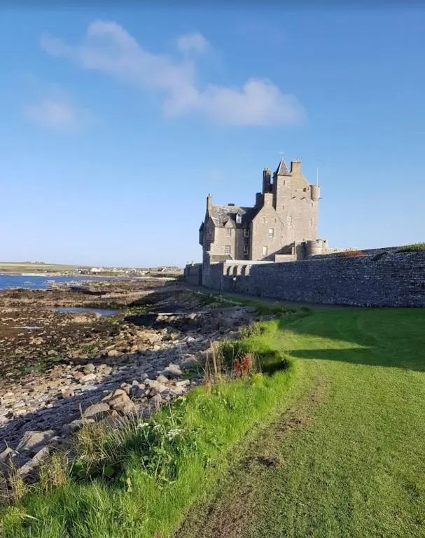 a castle on the shore of a body of water at Hot Tub Haven Farr North 2 in Wick