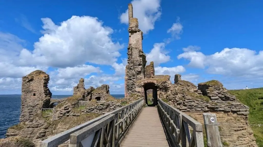 a bridge leading to an old castle on the water at Hot Tub Haven Farr North 2 in Wick