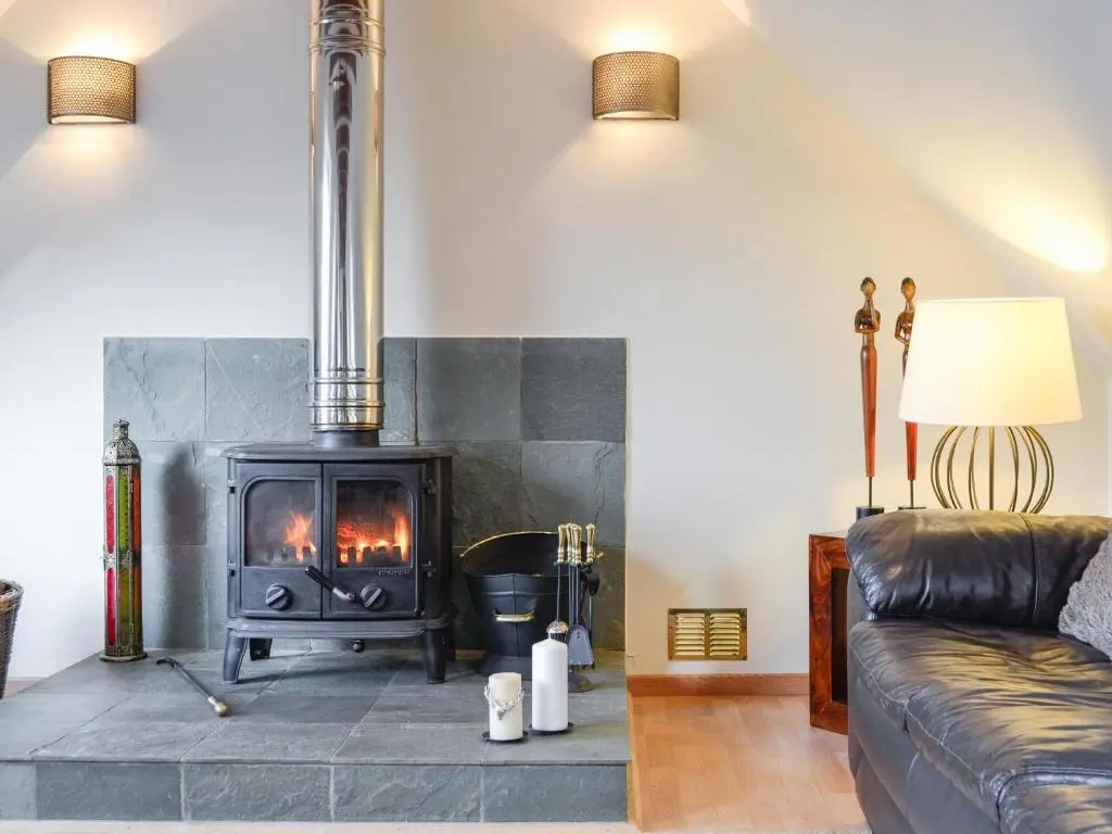 a living room with a fireplace and a couch at Dee Valley View in Aboyne