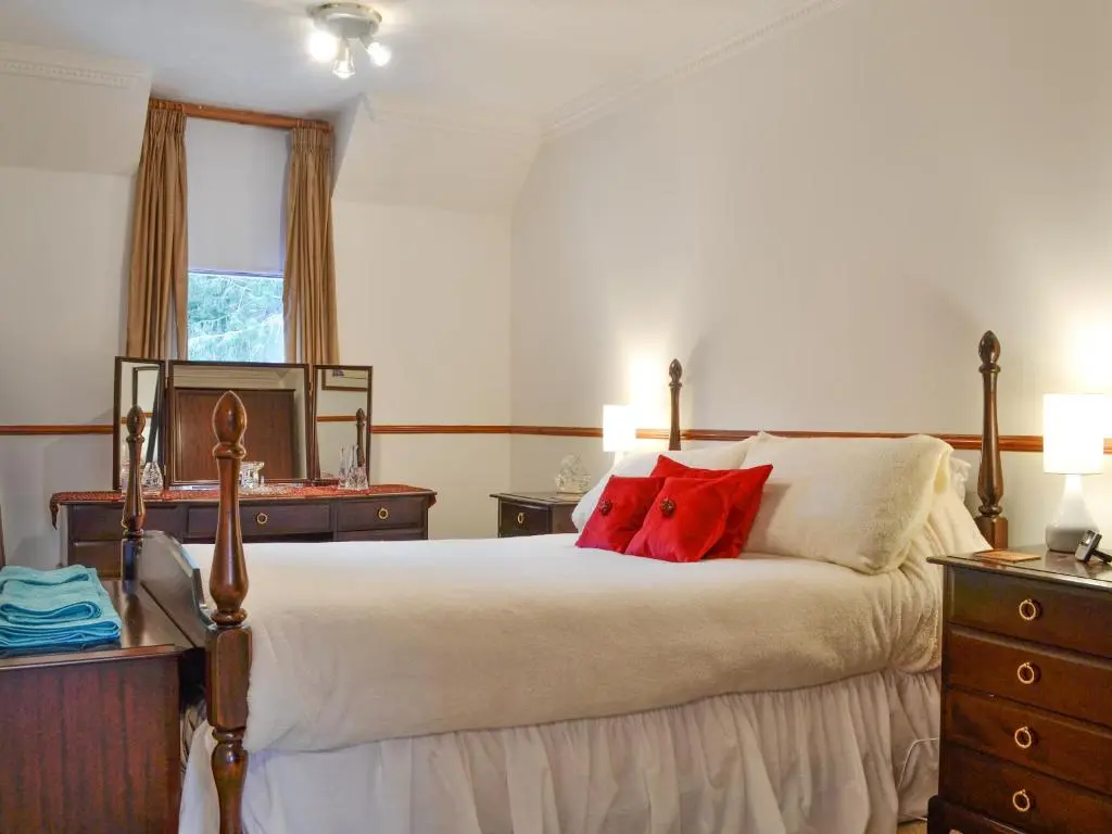 a bedroom with a bed with a red pillow on it at Dee Valley View in Aboyne