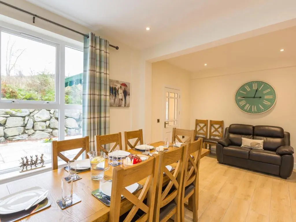a dining room with a table and chairs and a clock at Rose Cottage with Hot Tub in Cray