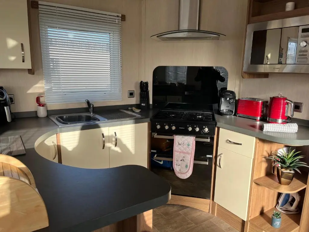 a small kitchen with a stove and a sink at Playa la Casa in Lossiemouth