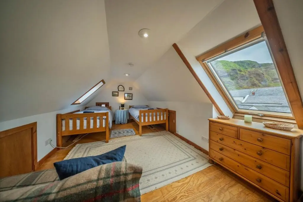 a attic room with a bed and a window at Fisherman's Cottage in Pennan in Pennan
