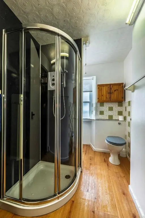 a bathroom with a shower with a toilet in it at Fisherman's Cottage in Pennan in Pennan