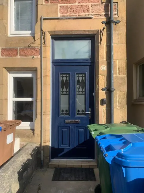 a blue door on the side of a building at Kenneth Street Apartment in Inverness