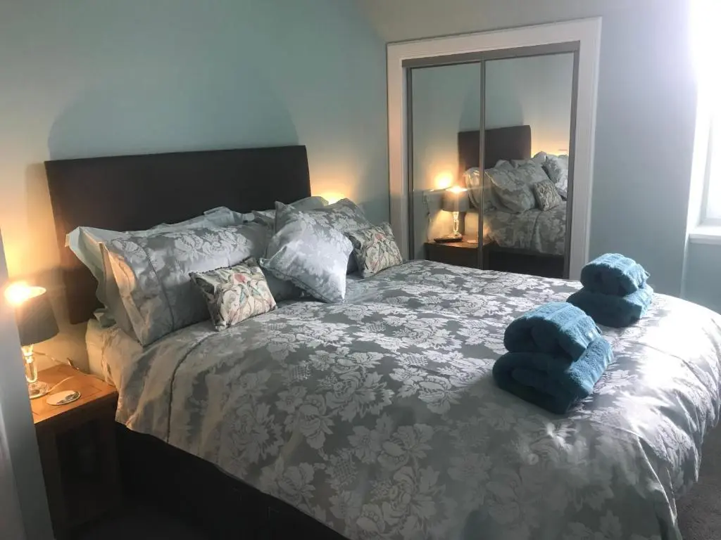 a bedroom with a bed with blue stuffed animals on it at Kenneth Street Apartment in Inverness