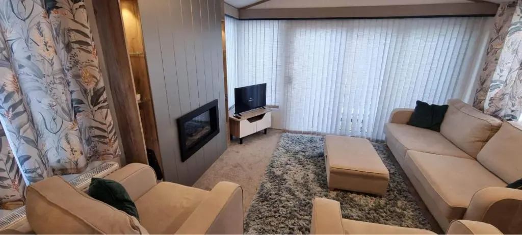a living room with a couch and a tv at Dee Lodge in Boat of Garten