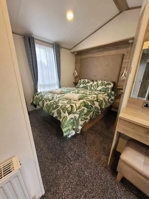 a small bedroom with a bed and a window at Dee Lodge in Boat of Garten