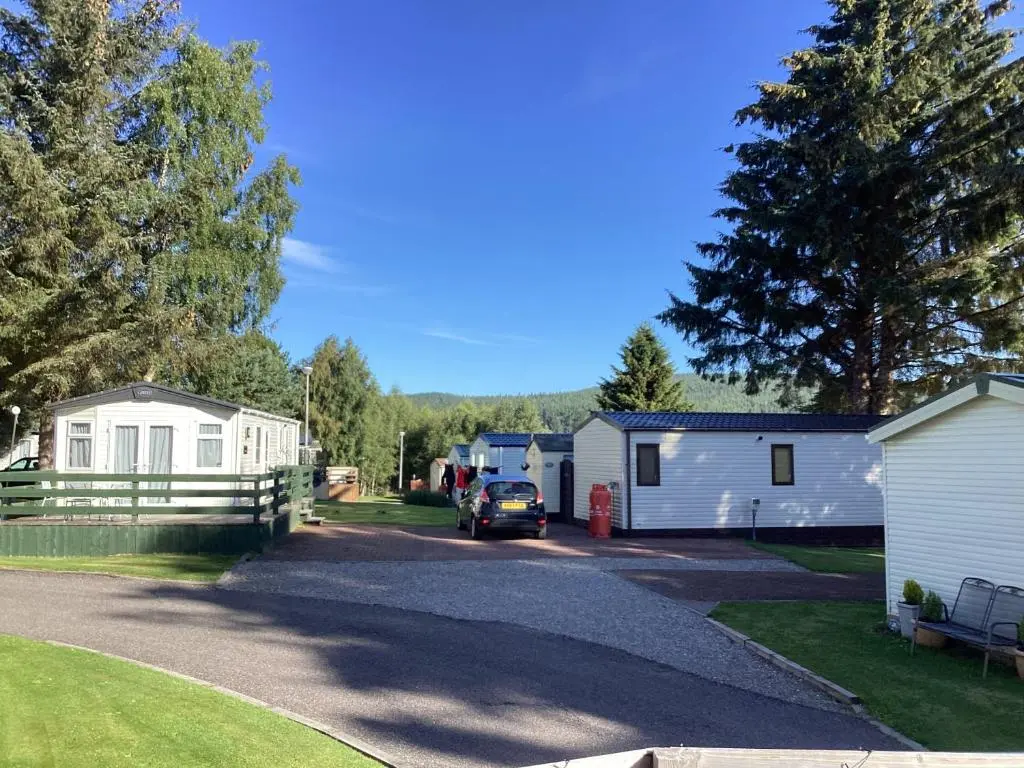 a campsite with a car parked in a driveway at Dee Lodge in Boat of Garten