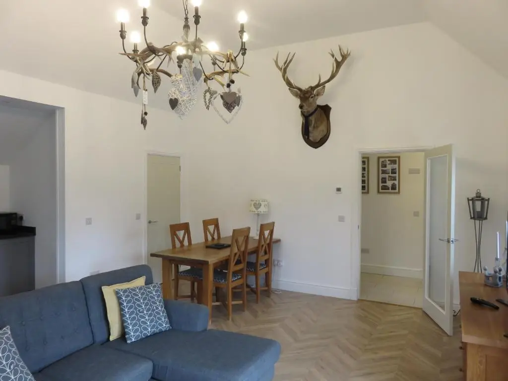 a living room with a blue couch and a table at Old Schoolhouse in Lairg